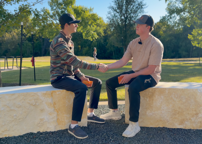 Two men shake hands.