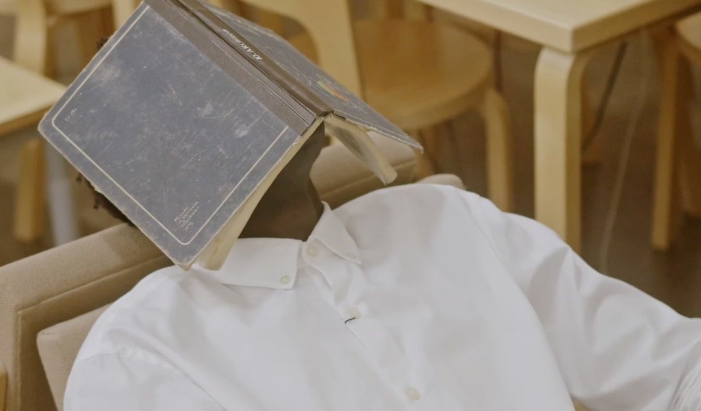 I Don't Believe in the Bible. Man sleeping under a book.
